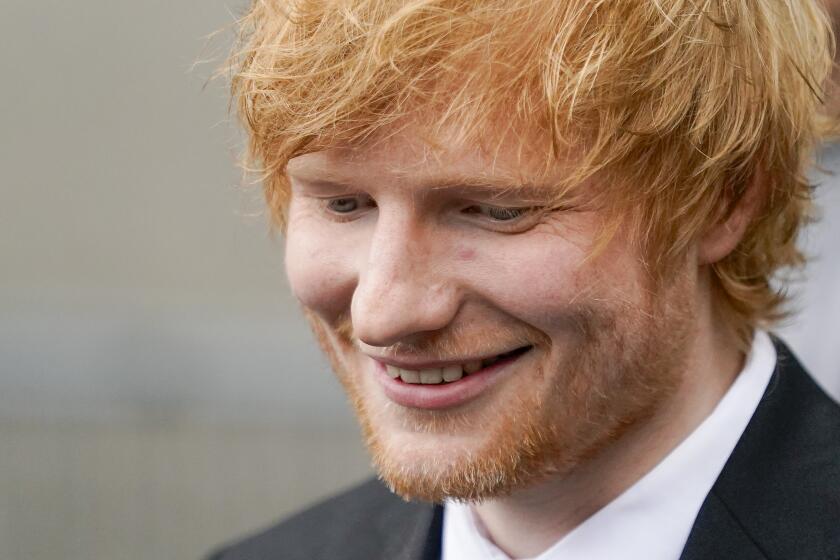 Ed Sheeran in a suit smiling 