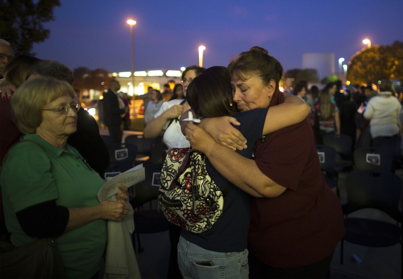 Trenna Meins, right, of Riverside, hugs friends and family during a vigil t the Riverside County Health Complex for her husband, Damian Meins, and 13 others killed in the San Bernardino shooting rampage.