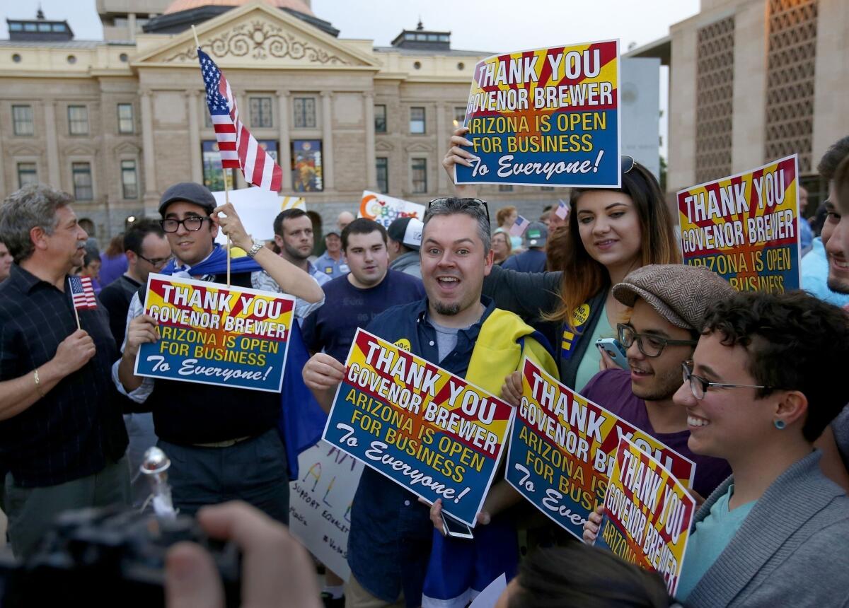 Demonstrators celebrate Wednesday after learning that Arizona Gov. Jan Brewer had vetoed a bill designed to give added protection from lawsuits to people who assert their religious beliefs in refusing service to gay people and others.
