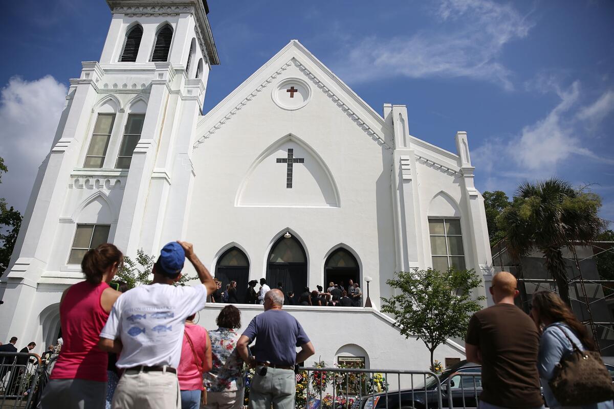 People look on as mourners file into the funeral of Cynthia Hurd, 54, at the Emanuel African Methodist Episcopal Church where she was killed along with eight others in a mass shooting at the church on June 27, 2015 in Charleston, S.C.