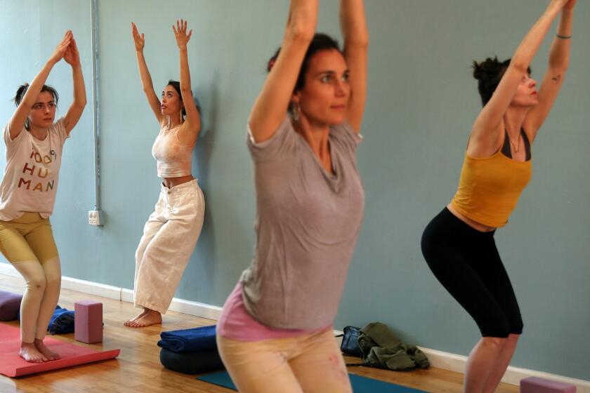 LOS ANGELES, CALIFORNIA-FEBRUARY 11, 2020: Kat Mills, second left, leads a class of Prana Yoga at Yogala, an Echo Park yoga studio, on February 11, 2020, in Los Angeles, California. In response to AB 5, the controversial new law curbing the use of independent contractors, Yogala's founder Samantha Garrison is converting her 40 part-time yoga teachers to employee status. (Photo By Dania Maxwell / Los Angeles Times)