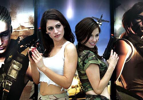 Models Natalie Haddad, left, and Ali Costello promote K2 Network's "War Rock" during the Electronic Entertainment Expo at the Los Angeles Convention Center on Thursday.