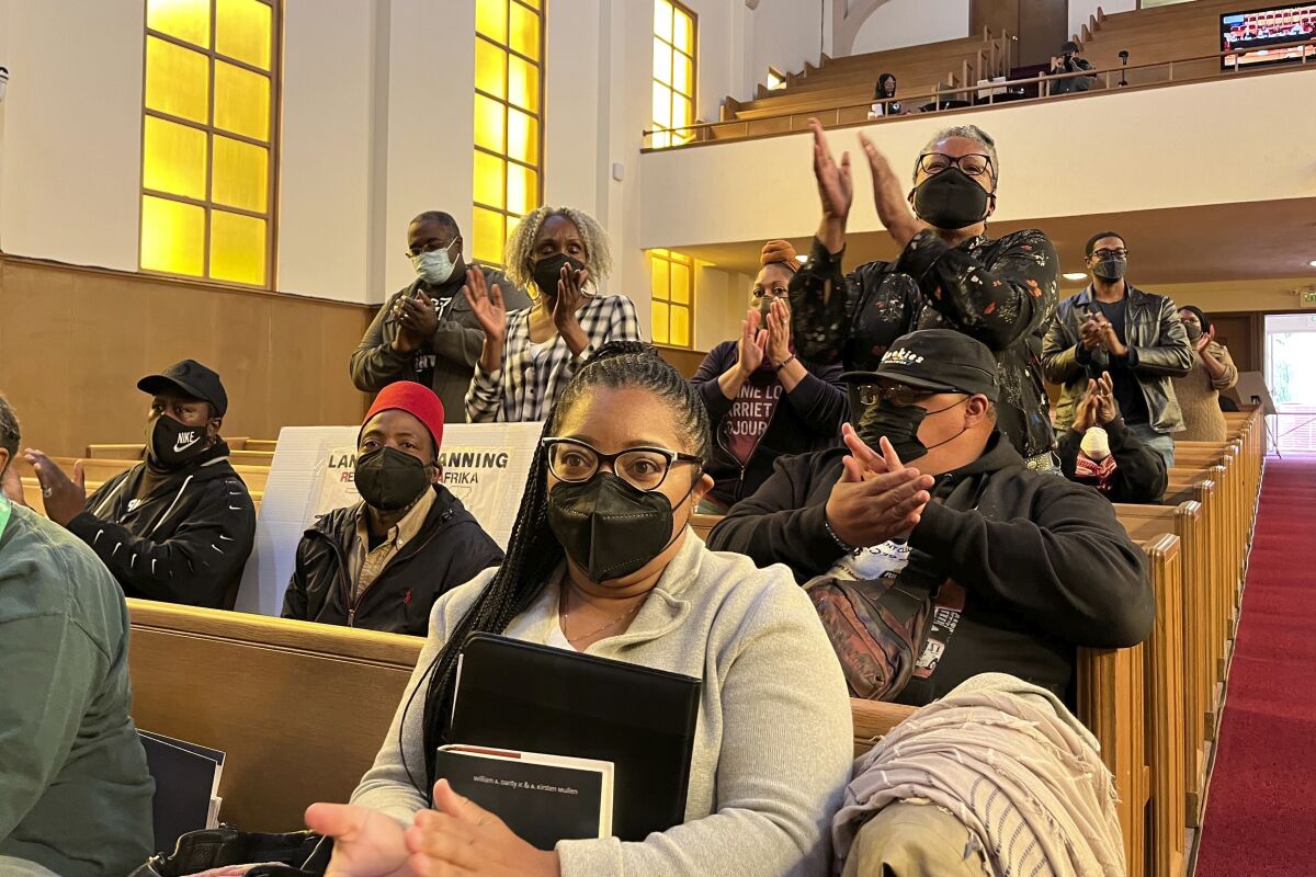 People applaud chair Kamilah Moore during a reparations task force meeting in San Francisco on Wednesday.