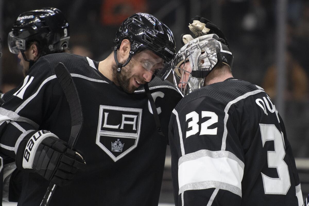 Kings captain Anze Kopitar celebrates with Jonathan Quick after a win over the Philadelphia Flyers on Jan. 1, 2022.