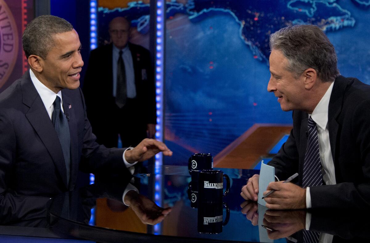 In this Oct. 18, 2012, file photo, President Barack Obama talks with Jon Stewart during a taping of his appearance on "The Daily Show." Obama is booked for his seventh appearance on the show Tuesday, as Stewart begins his final three weeks as host.