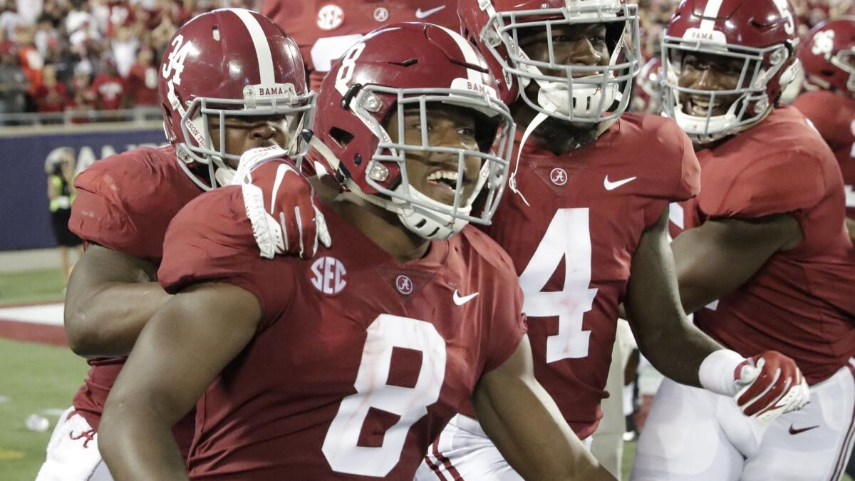 Alabama's Josh Jacobs (8) celebrates his 77-yard touchdown run against Louisville with teammates during the second half on Saturday in Orlando, Fla.