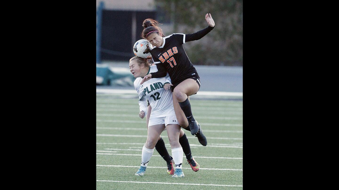 Huntington Beach's Maddie Phantumabamrung heads the ball over Upland's Payton Dyer in a CIF Southern Section Division I second-round girls' soccer game at Upland High School on Tuesday, February 20, 2018. Upland won the game 3-1.