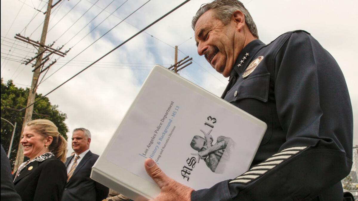 LAPD chief Charlie Beck reads the research on MS-13 gang before addressing a press conference. (Irfan Khan / Los Angeles Times)