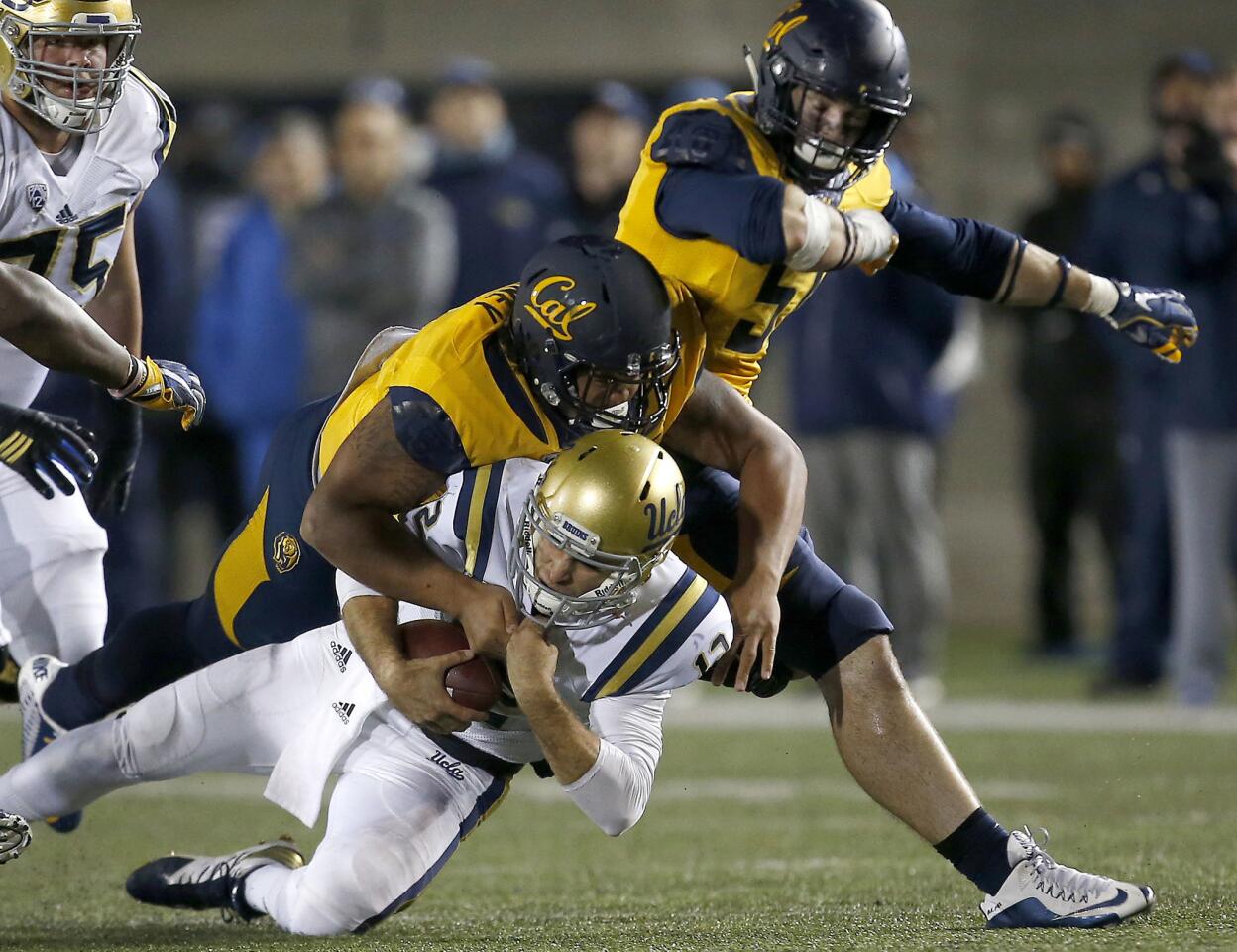UCLA quarterback Mike Fafaul (12) is sacked by California defensive tackle James Looney (9) and defensive end Cameron Saffle, right, during the second half.