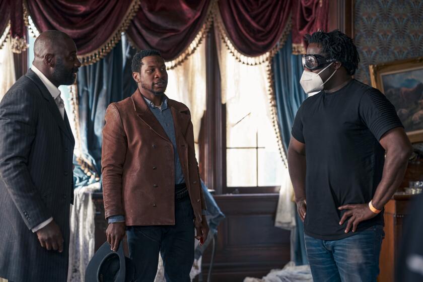 From left, Idris Elba as Rufus Buck and Jonathan Majors as Nat Love with writer-director Jeymes Samuel