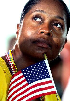 Carmen Helasse, originally from Trinidad and Tobago, holds the U.S. flag during a naturalization ceremony conducted by the U.S. Citizenship and Immigration Services at the Newseum in Washington, D.C.