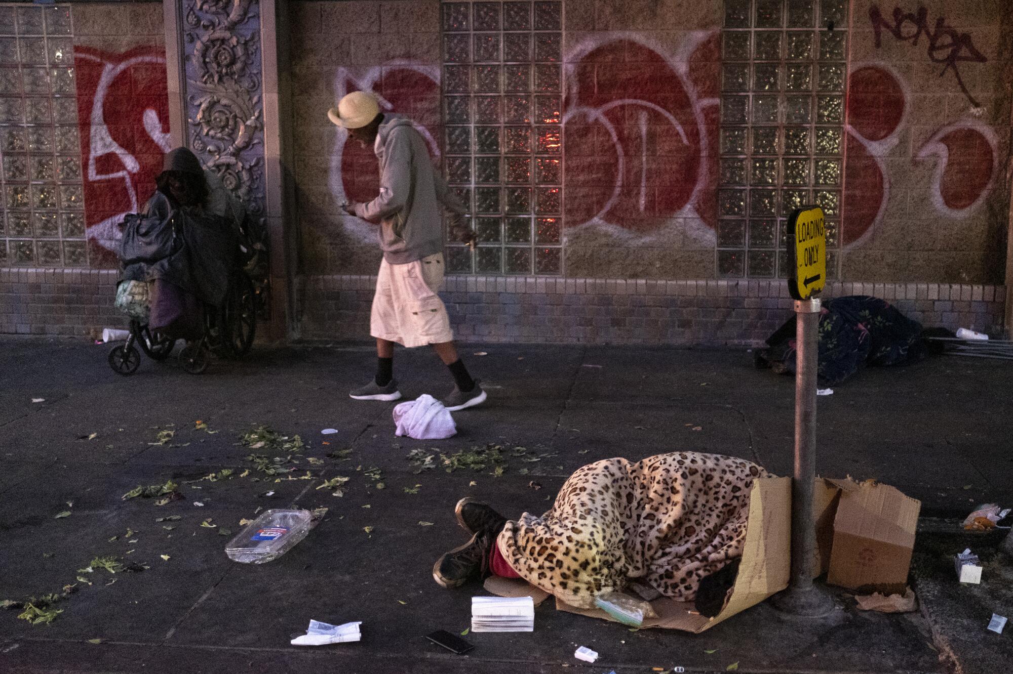 As the sun starts to rise at dawn, people start to wake up and move around on skid row in Los Angeles.