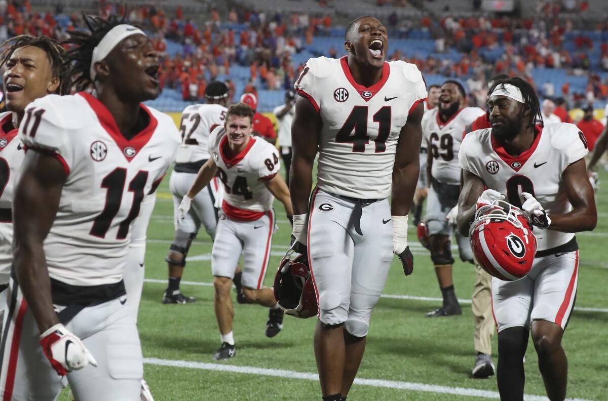 Georgia players celebrate a victory over Clemson in an NCAA college football game Saturday, Sept. 4, 2021, in Charlotte, N.C. (Curtis Compton/Atlanta Journal-Constitution via AP)