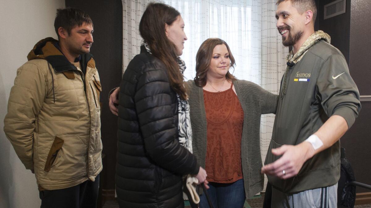 Erin Bond, center, 33, of Apple Valley, Minn., and her husband, John, right, 35, get ready to hug Olga Kemaeva, 34, the widow of Anton Kemaev, as they meet for the first time in 2017, in Pittsburgh. Bond believes he received Kemaev's kidney in a transplant operation.