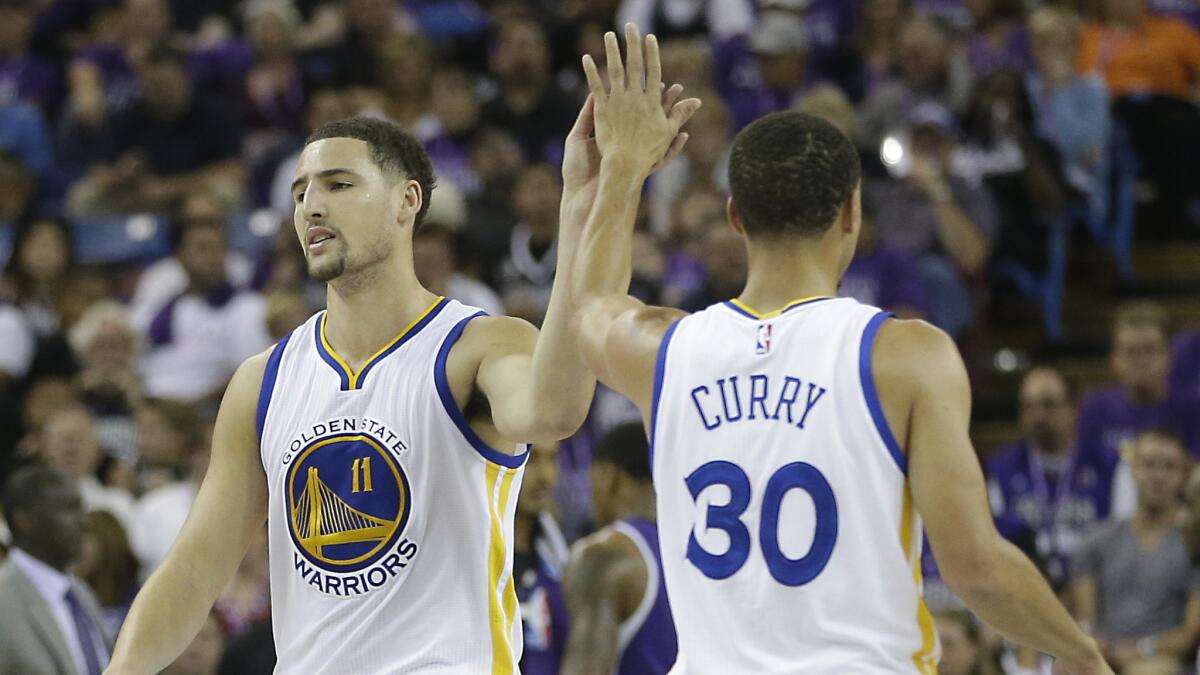 Golden State Warriors forward Klay Thompson, left, celebrates with teammate Stephen Curry after celebrating a basket during a 95-77 victory over the Sacramento Kings on Oct. 29.