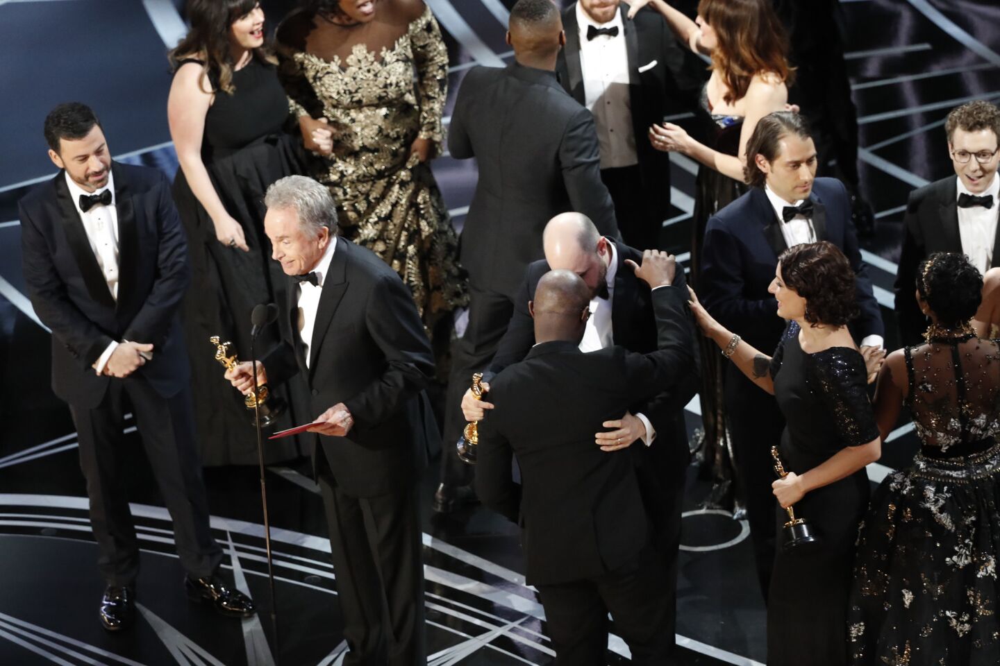 Presenter Warren Beatty and host Jimmy Kimmel try to explain to the audience how the wrong envelope for best picture was read onstage during the Academy Awards telecast on Feb. 26. At right are "Moonlight" writer/director Barry Jenkins, left, and "La La Land" producer Jordan Horowitz embracing.