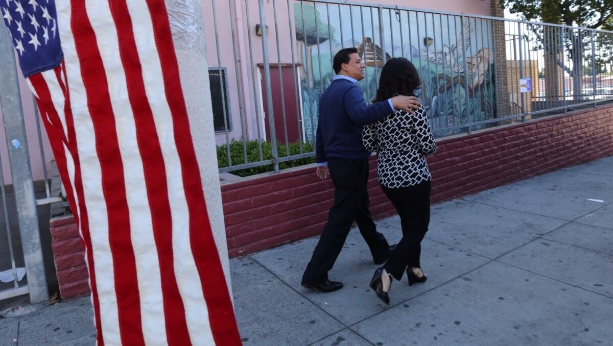 Jose Huizar and his wife Richelle walk out after casting their votes at Sheridan Street School in Los Angeles on March 3, 2015.