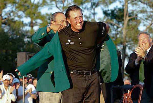 Phil Mickelson is presented with the ceremonial green jacket by last year's Masters champion Angel Cabrera on Sunday at Augusta National Golf Club.
