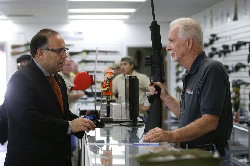 In this Dec. 9, 2015, photo, sales associate Mike Conway, right, shows Paul Angulo a semiautomatic rifle at Bullseye Sport gun shop in Riverside, Calif. The massacre at Sandy Hook elementary school in which a mentally disturbed young man killed 26 children and teachers galvanized calls across the nation for tighter gun controls. But in the three years since, many states have moved in the opposite direction, embracing the National Rifle Association's response that more "good guys with guns" are what's needed to limit the carnage of mass shootings. (AP Photo/JÆ C. Hong) ORG XMIT: CAJH902