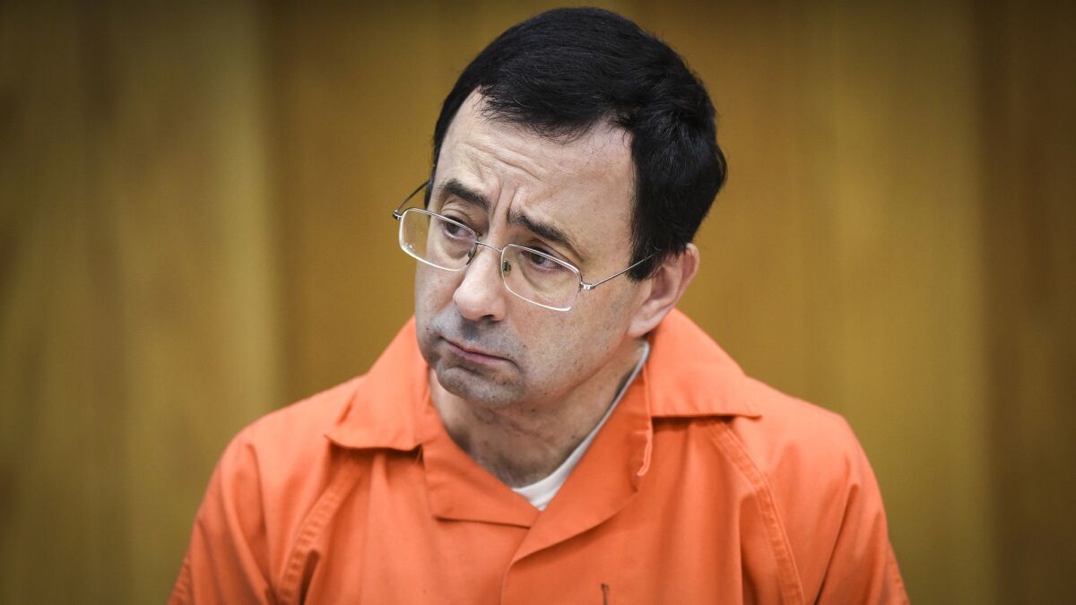 Larry Nassar listens to one of his victims give her impact statement in 2018.