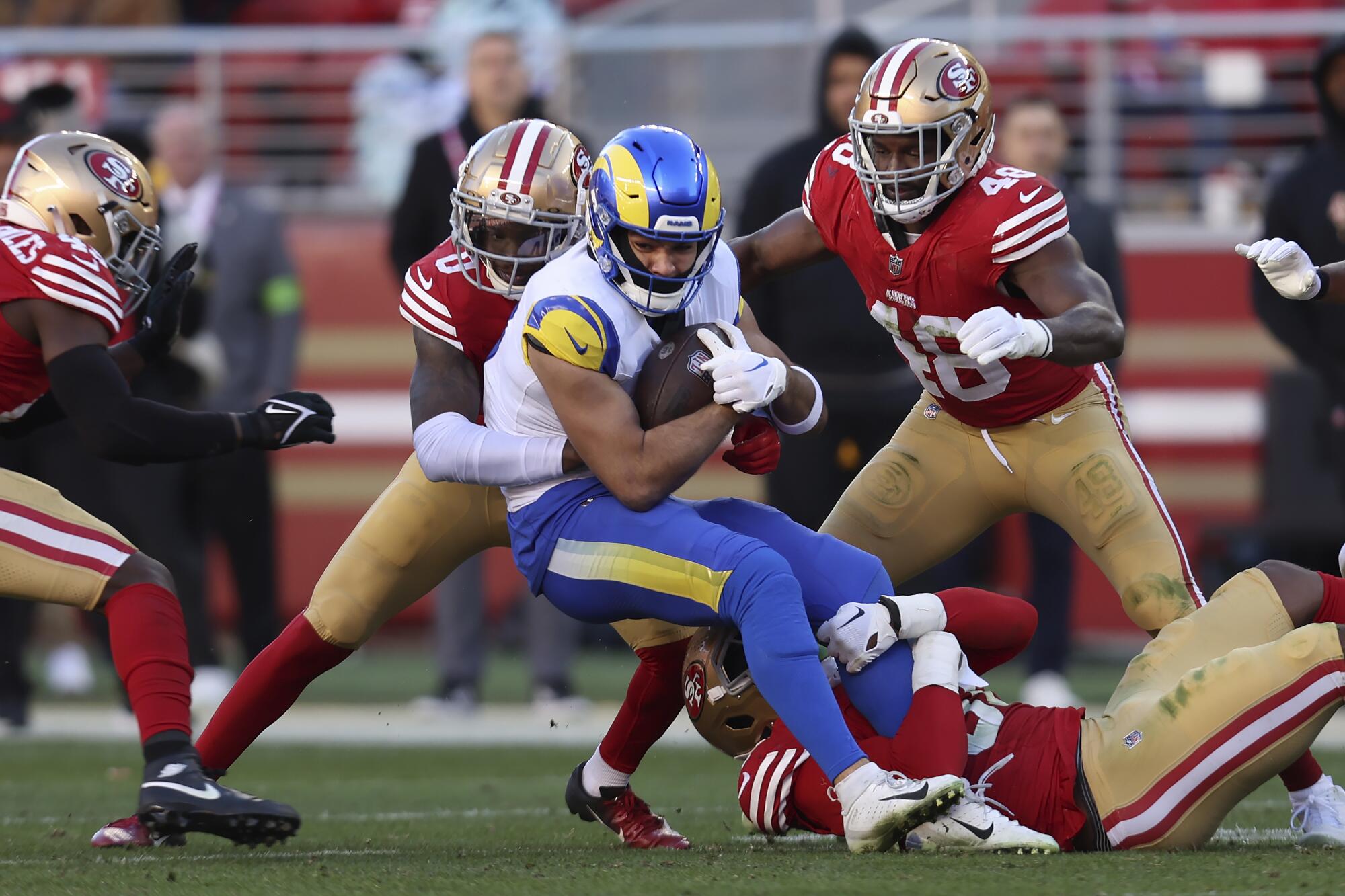 Rams wide receiver Puka Nacua, middle, is tackled after catching a pass against the San Francisco 49ers.