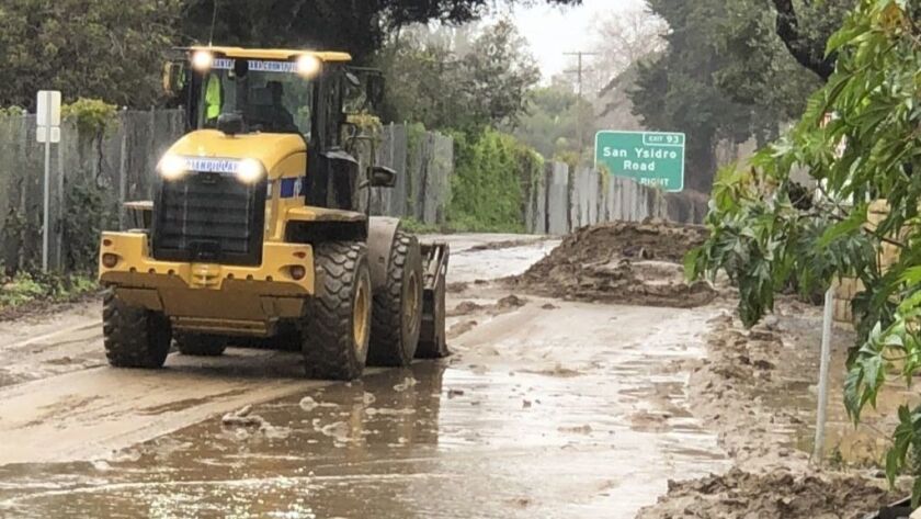 Workers clear mud from Jameson Lane in Santa Barbara County after a storm in early February. Another storm arrived Tuesday.