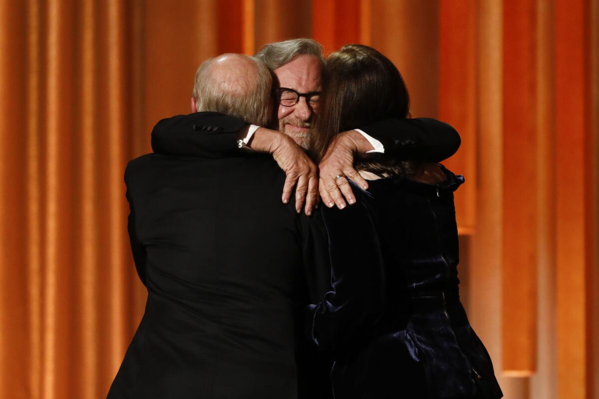 Steven Spielberg hugs producers Kathleen Kennedy and Frank Marshall as he presents them the Irving G. Thalberg Memorial Award.