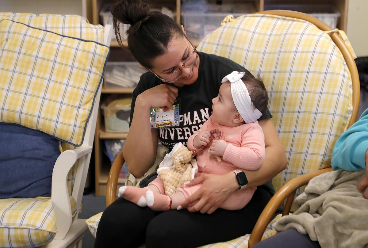 Volunteer "holder" Angie plays with an infant at the early intervention program in Laguna Beach on Wednesday.