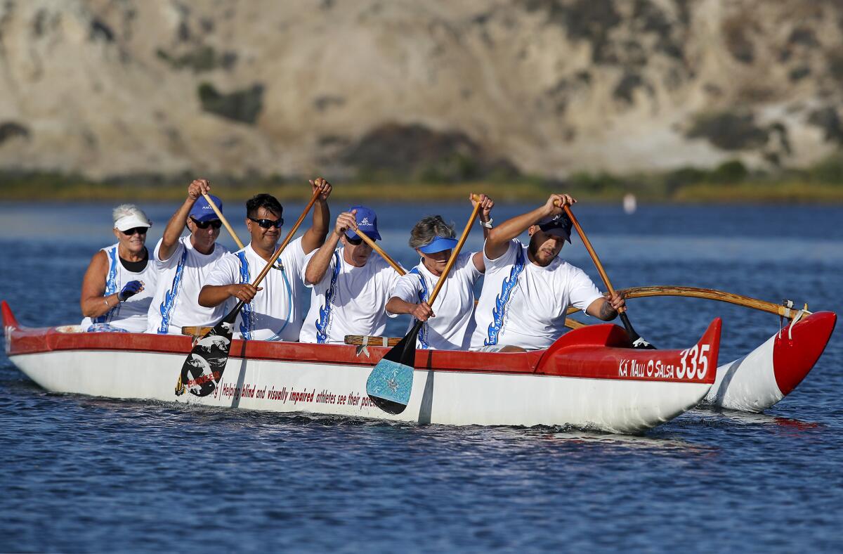 Four visually impaired athletes join two sighted ones on the NAC/Makapo Outrigger Team as they paddle by the Newport Aquatic Center on Monday during their final practice for this weekend's Queen Lili’uokalani Canoe Race in Hawaii. They are the only predominantly blind team competing in the event.