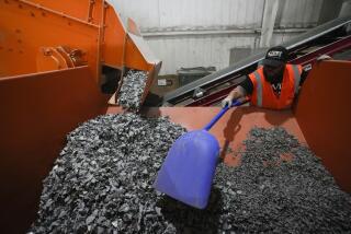 K.C. Skillern moves material with a shovel from recycled solar panels at We Recycle Solar on Tuesday, June 6, 2023, in Yuma, Ariz. North America’s first utility-scale solar panel recycling plant opened to address what founders of the company call a “tsunami” of solar waste, as technology that became popular in the early 2000s rapidly scales up. (AP Photo/Gregory Bull)