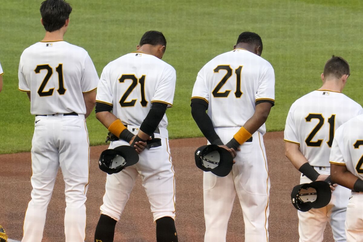 Pittsburgh Pirates, all wearing Roberto Clemente's No. 21 for Roberto Clemente Day, watch a tribute to the Pirates Hall of Fame right fielder before the team's baseball game against the Chicago White Sox in Pittsburgh, Wednesday, Sept. 9, 2020. (AP Photo/Gene J. Puskar)