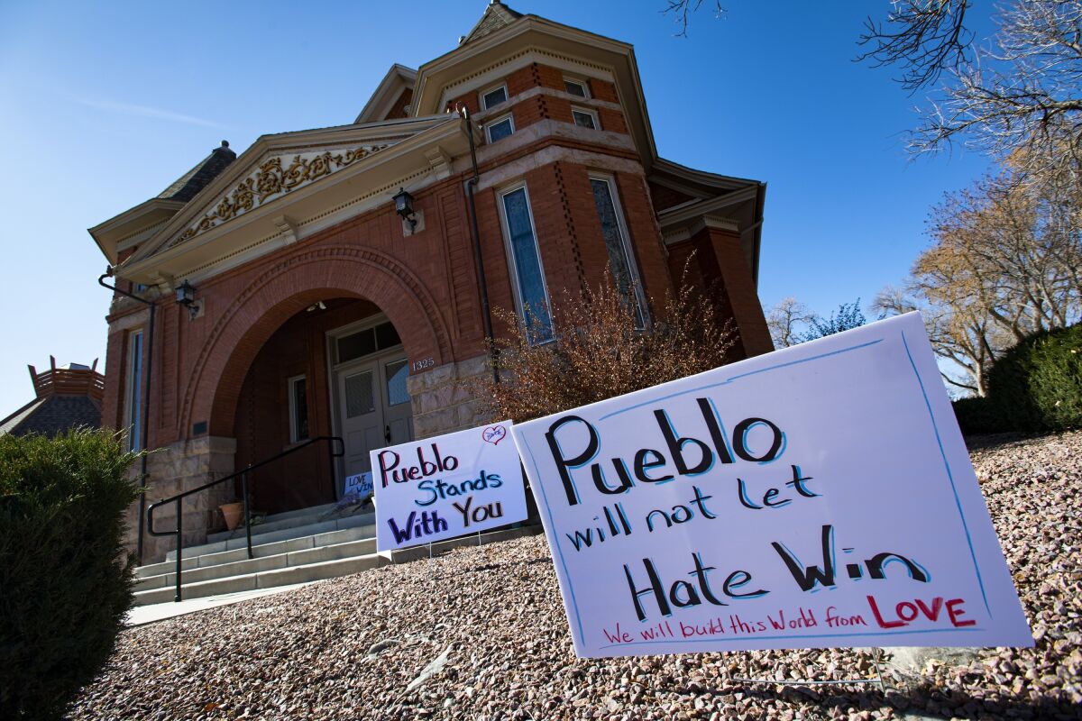 Signs, flowers and candles outside Temple Emanuel in Pueblo, Colo.
