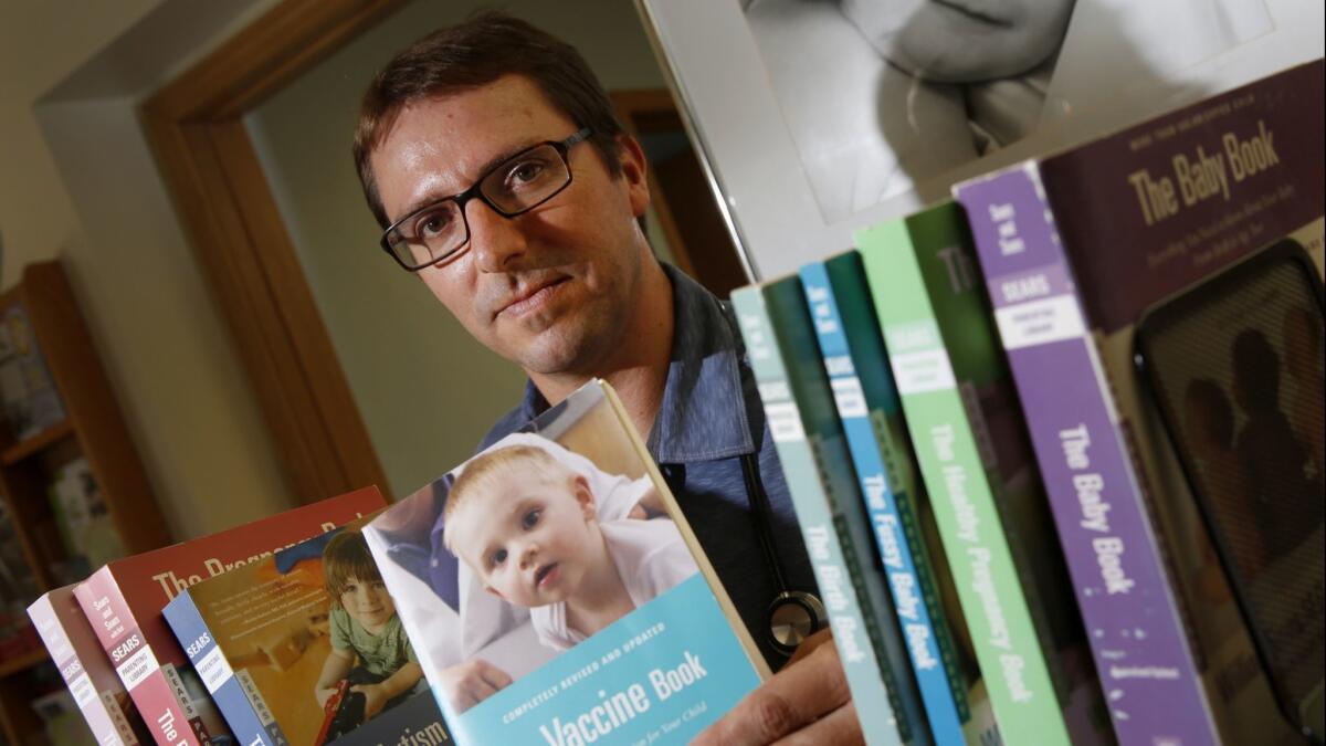 Dr. Bob Sears holding one of his titles, "The Vaccine Book," which explores the possible side effects from vaccinations.