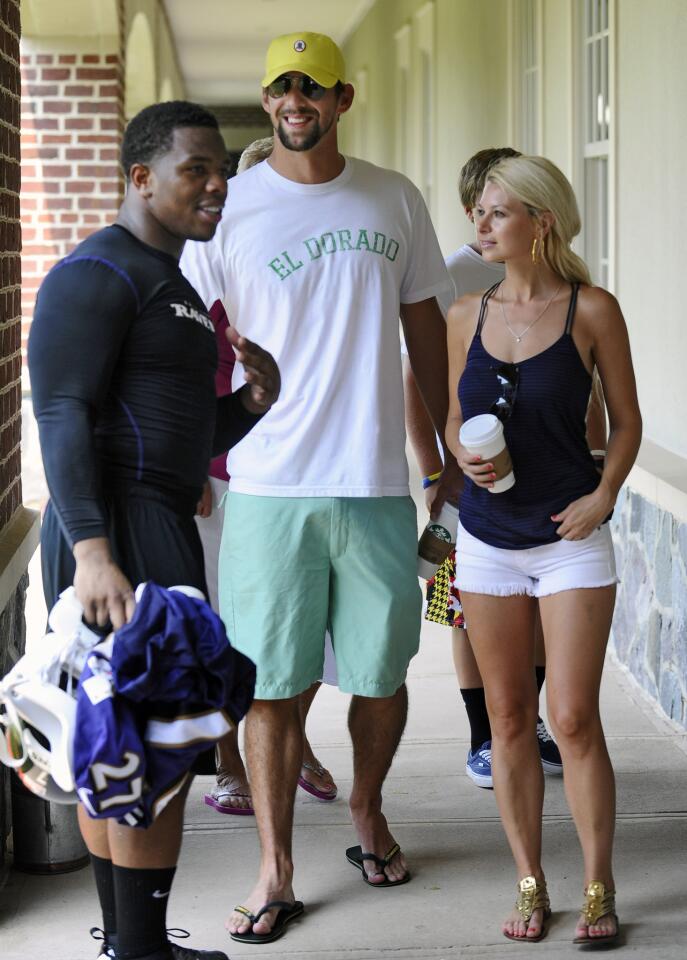 Michael Phelps and girlfriend Win McMurry chat with running back Ray Rice during Ravens training camp.