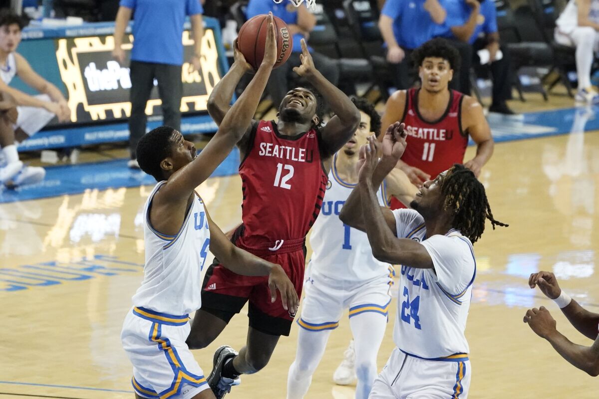 Seattle guard Darrion Trammell (12) drives between UCLA defenders during a December 2020 game at Pauley Pavilion.