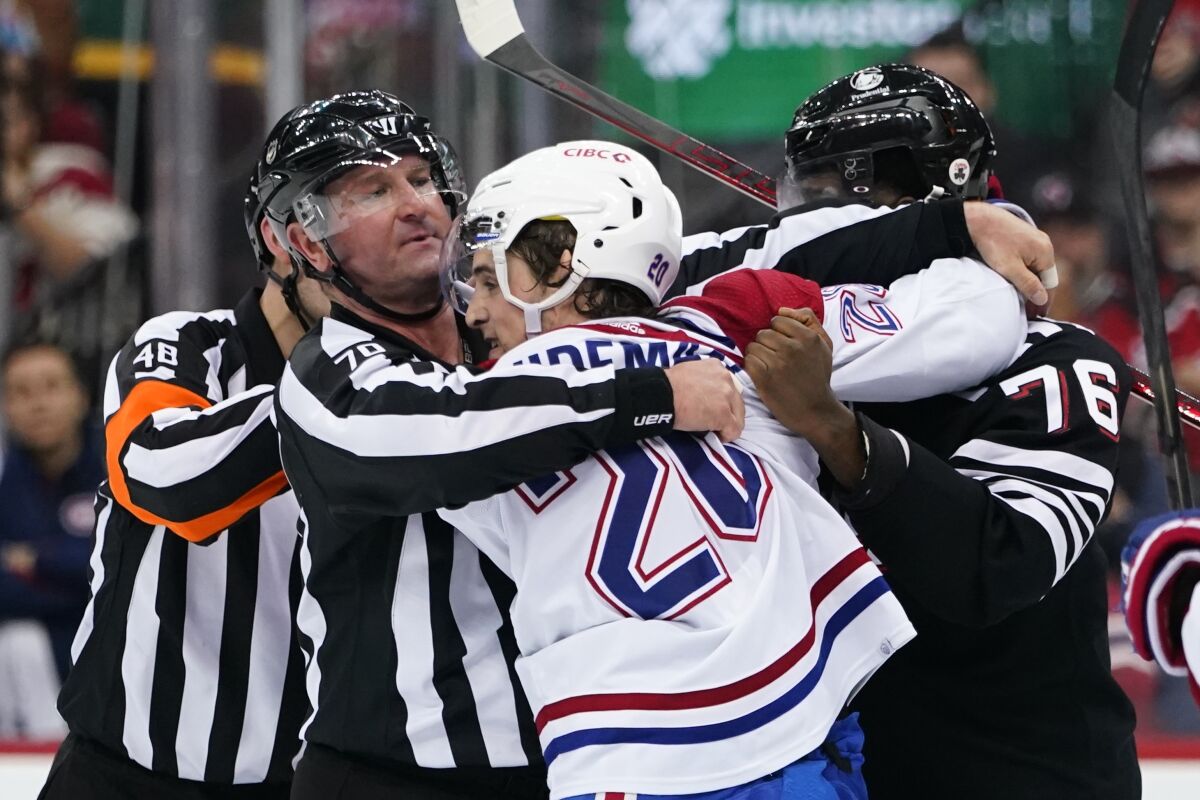 Linesman Derek Nansen (70) separates Montreal Canadiens' Chris Wideman (20) and New Jersey Devils' P.K. Subban (76) after a goal by Canadiens' Joel Armia during the second period of an NHL hockey game Thursday, April 7, 2022, in Newark, N.J. (AP Photo/Frank Franklin II)