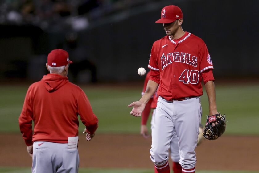 Los Angeles Angels pitcher Steve Cishek, right, is taken out of the game by manager Joe Maddon, left, during the sixth inning against the Oakland Athletics in a baseball game in Oakland, Calif., Tuesday, June 15, 2021. (AP Photo/Jed Jacobsohn)
