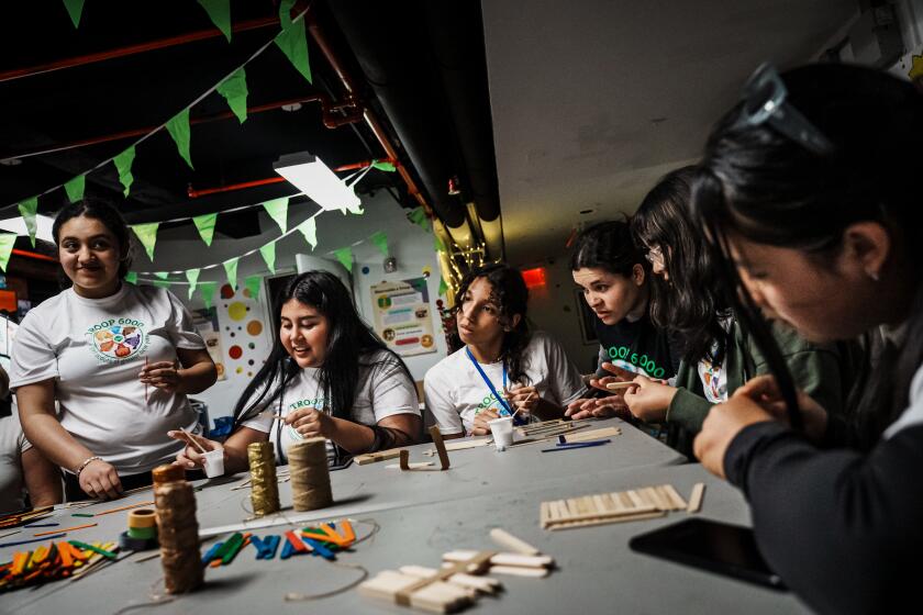 NEW YORK, UNITED STATES -- MAY 16, 2024: Ramona, center, listen as the girls from the Girl Scouts Troops 6000 expansion program receive instructions on how to make their art projects during a weekly meeting at the Row Hotel which was converted by the city into temporary housing for and migrants and asylum seekers, in New York, N.Y., Thursday, May 16, 2024. (MARCUS YAM / LOS ANGELES TIMES)