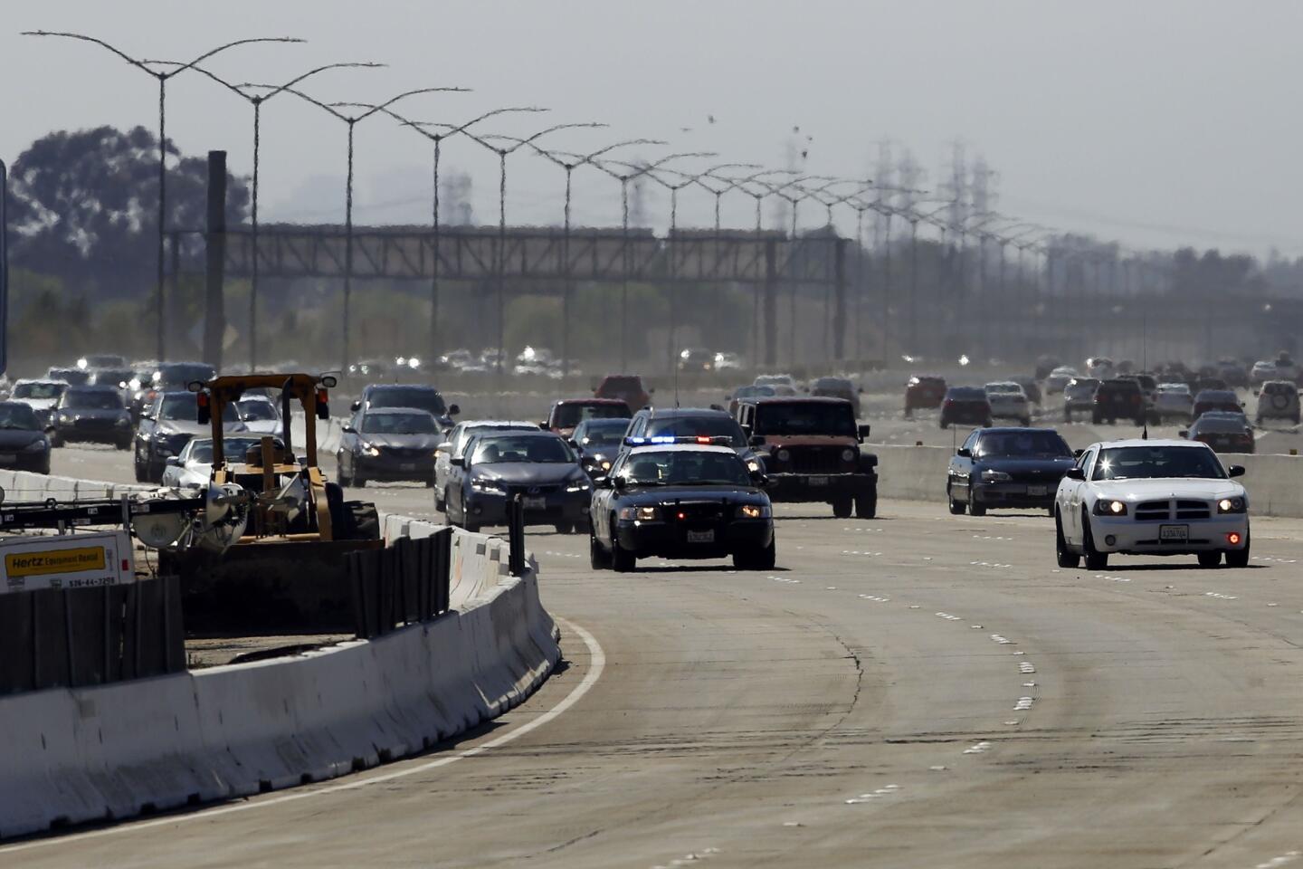 Police cars lead the way as the 405 Freeway in Orange County reopens.