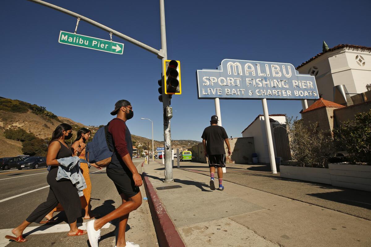 Pedestrians head toward the entrance to Malibu Pier.