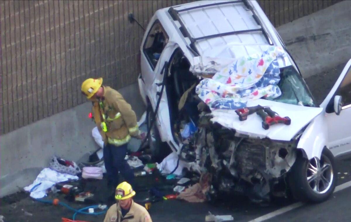 A mangled SUV is examined by firefighters 