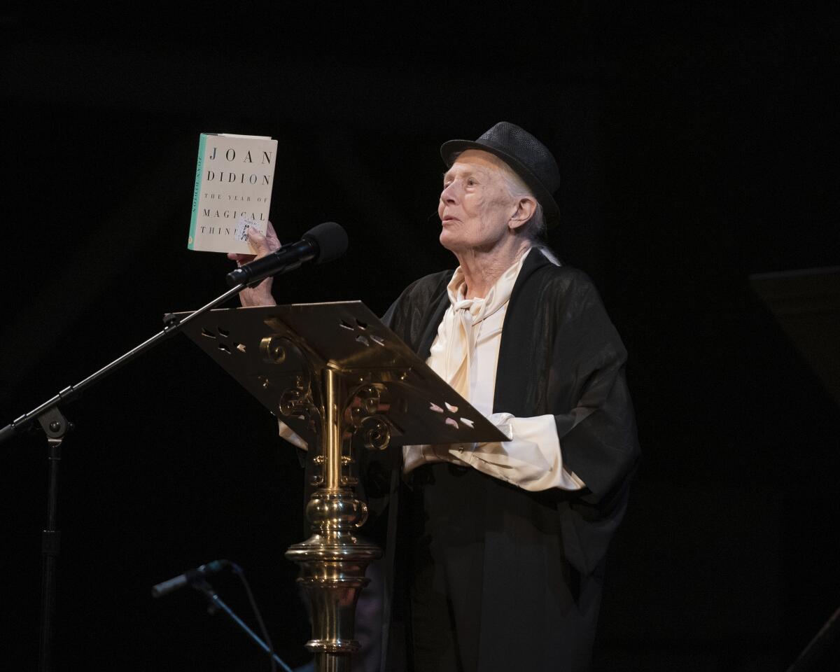 Actor Vanessa Redgrave holding up a book by Joan Didion