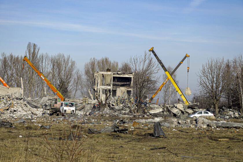 Workers clean rubbles after Ukrainian rocket strike in Makiivka, in Russian-controlled Donetsk region, eastern Ukraine, Tuesday, Jan. 3, 2023. Russia's defense ministry says 63 of its soldiers have been killed by a Ukrainian strike on a facility in the eastern Donetsk region where military personnel were stationed. (AP Photo)