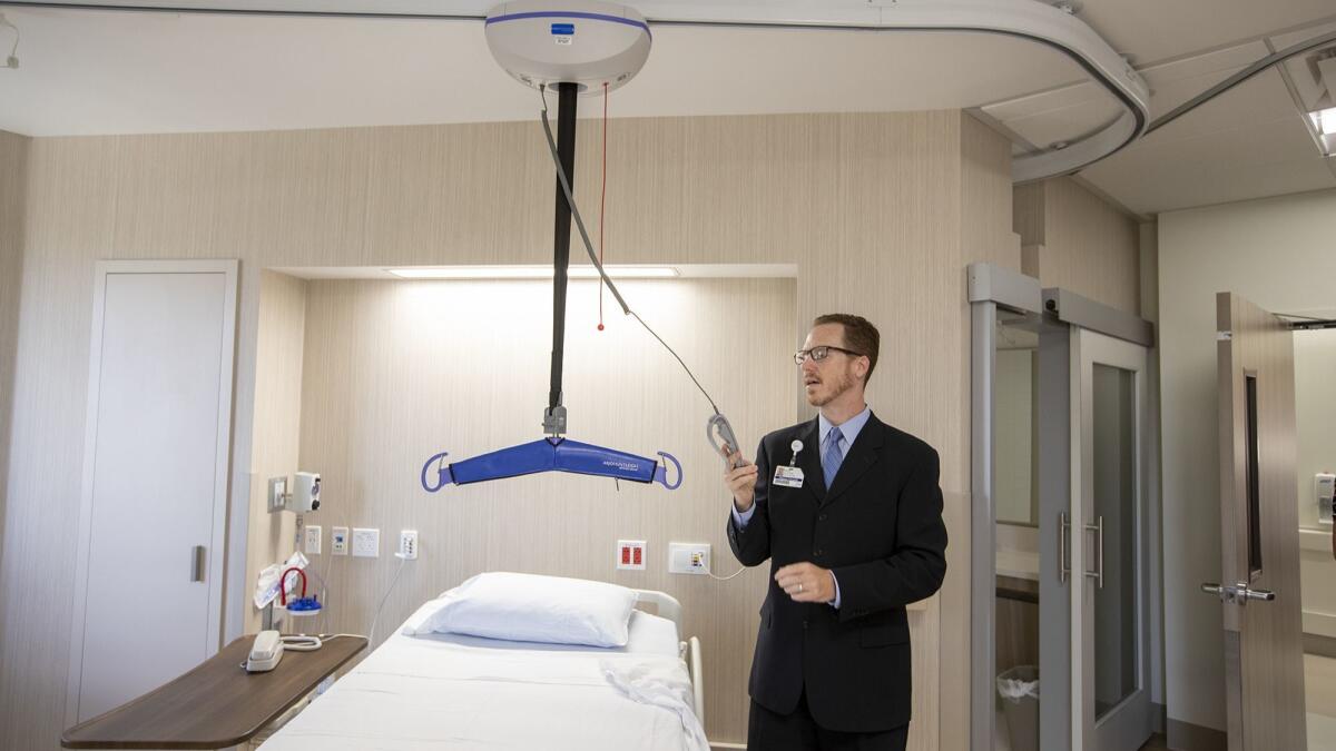 Mark Glavinic, director of rehabilitation for Hoag Hospital, demonstrates a lift at the Fudge Family Acute Rehabilitation Center for patients who have a hard time supporting themselves.