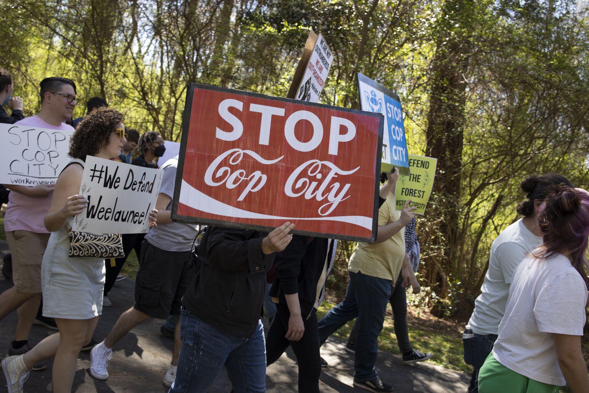 Environmental activists hold signs, one reading 