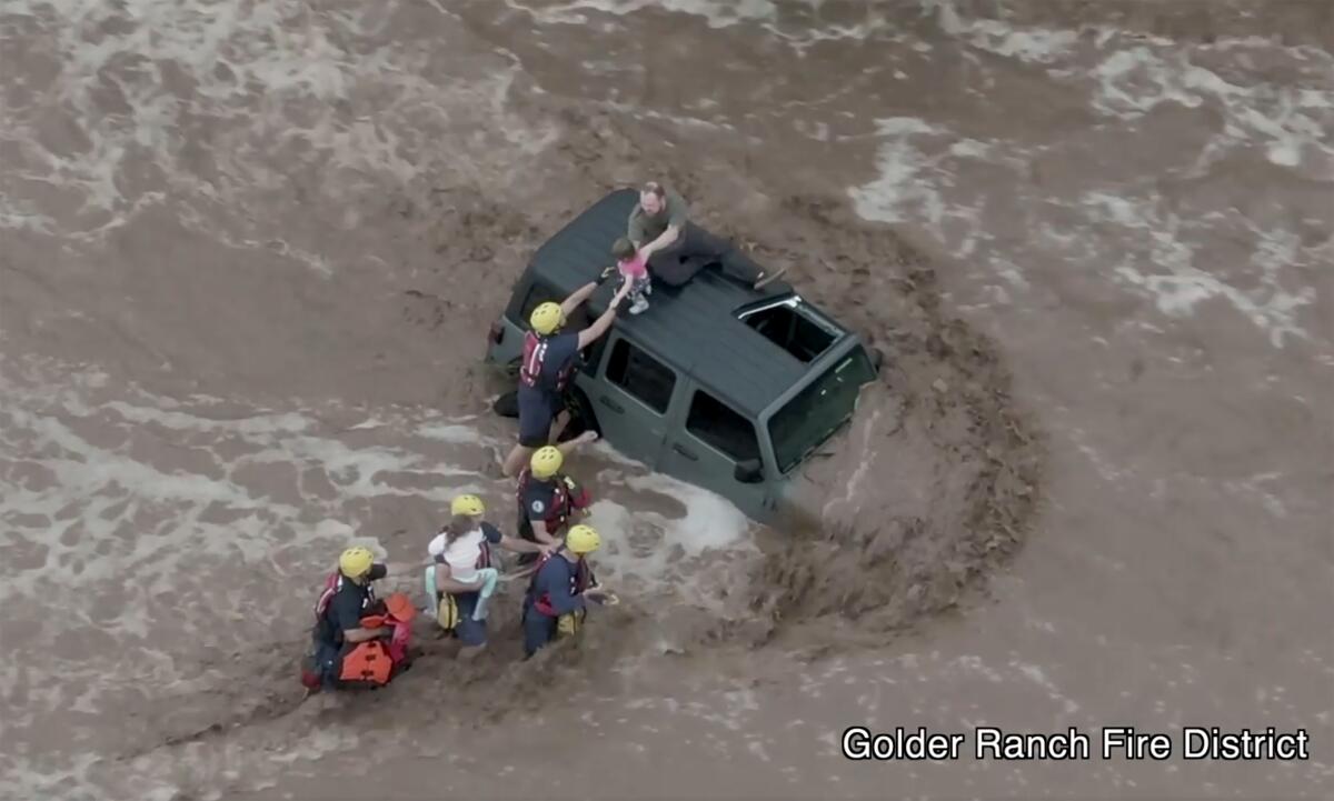 Firefighters rescuing people from vehicle caught in flood