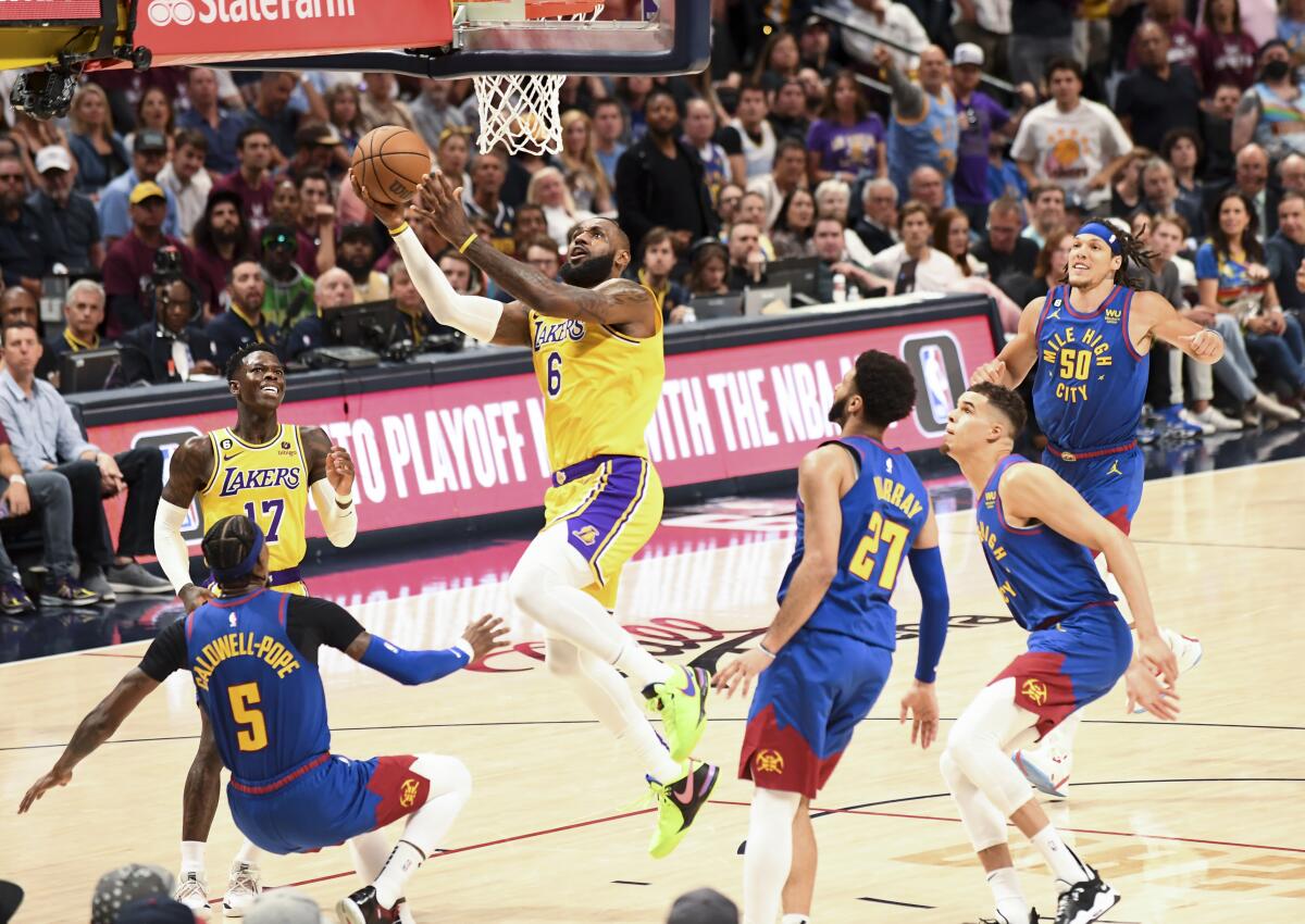 LeBron James glides to the basket for a layup as Nuggets guard Kentavious Caldwell-Pope attempts to draw a charge.