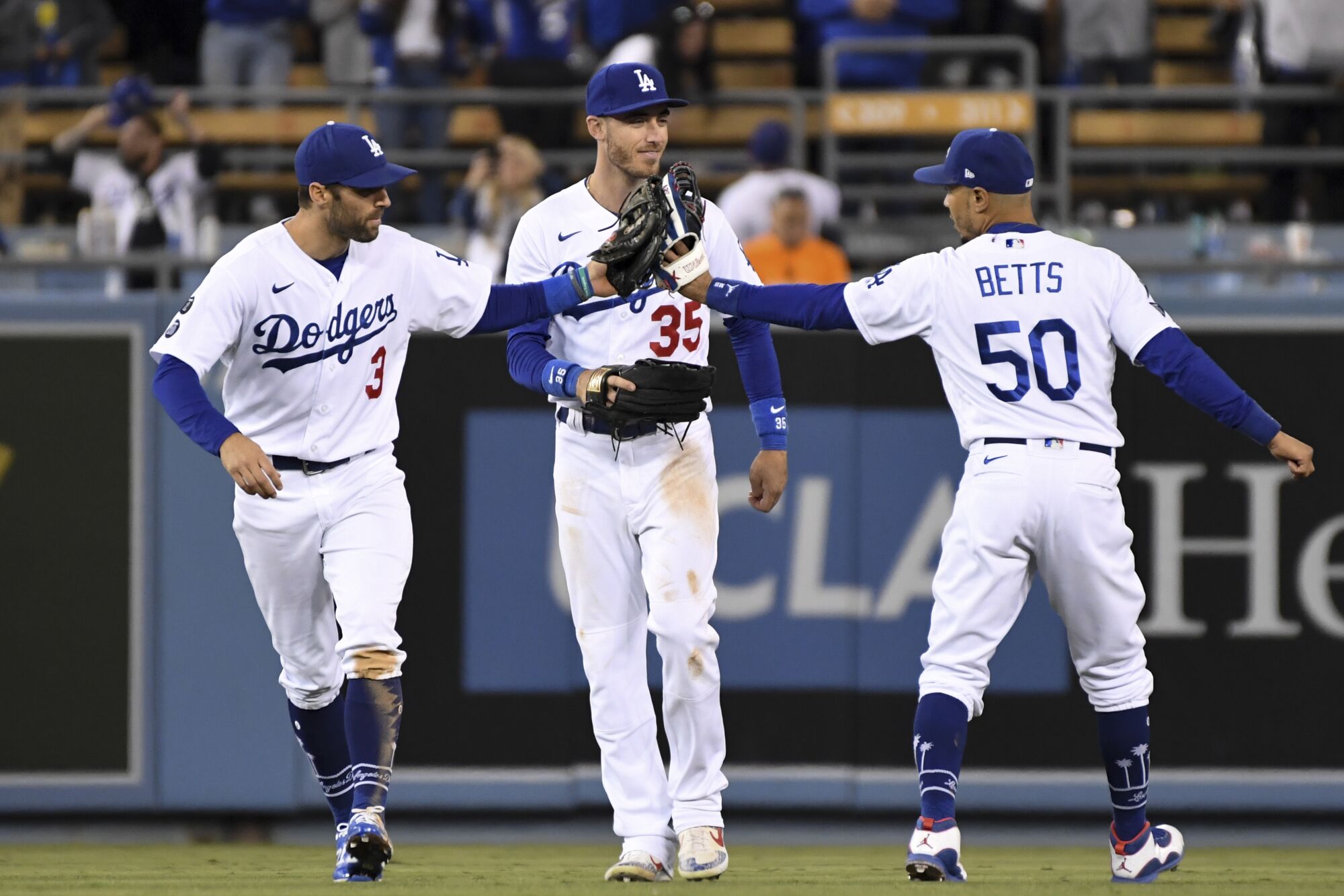 Los Angeles Dodgers' Chris Taylor, from left, celebrates with Cody Bellinger and Mookie Betts after game four