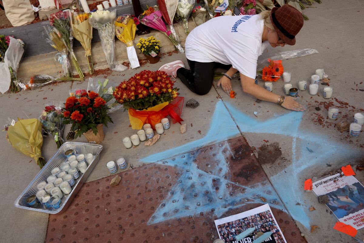 A member of the Hamakom synagogue creates a Star of David in chalk on a sidewalk