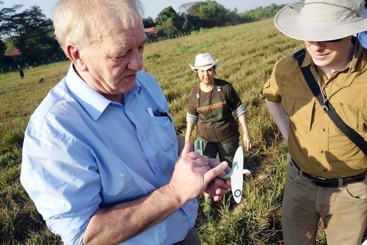 David Cundall, left, shows a model of a Spitfire plane to Tracy Spaight of Belarusian video game company Wargaming.net near the Yangon airport in Myanmar. The firm has since pulled its sponsorship of the effort to find a trove of actual vintage Spitfires that Cundall believes is buried nearby.